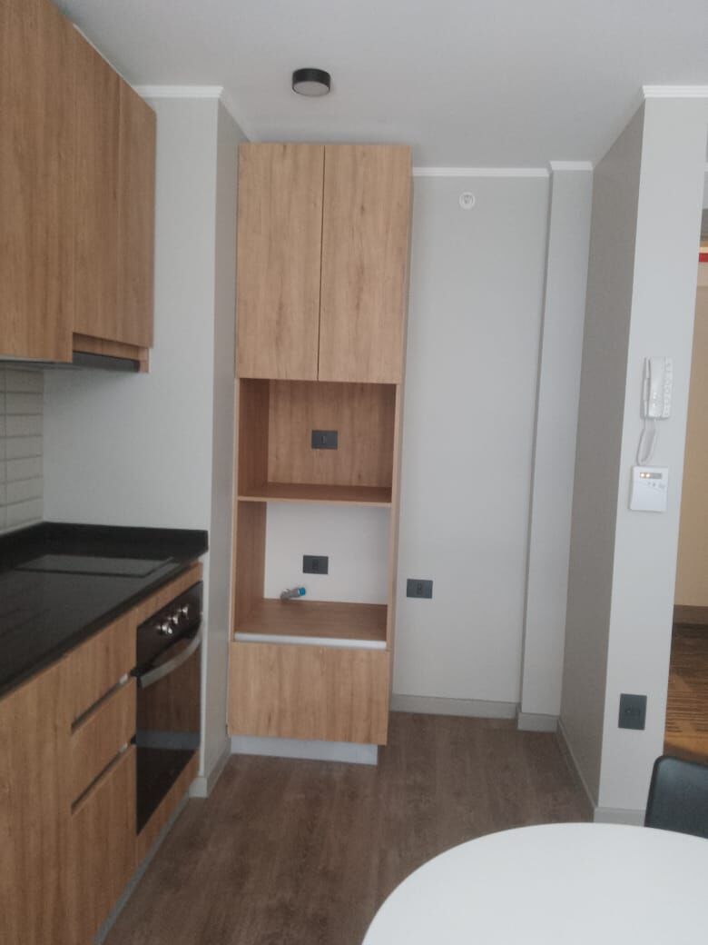 Cocina de departamento terminada con muebles de madera